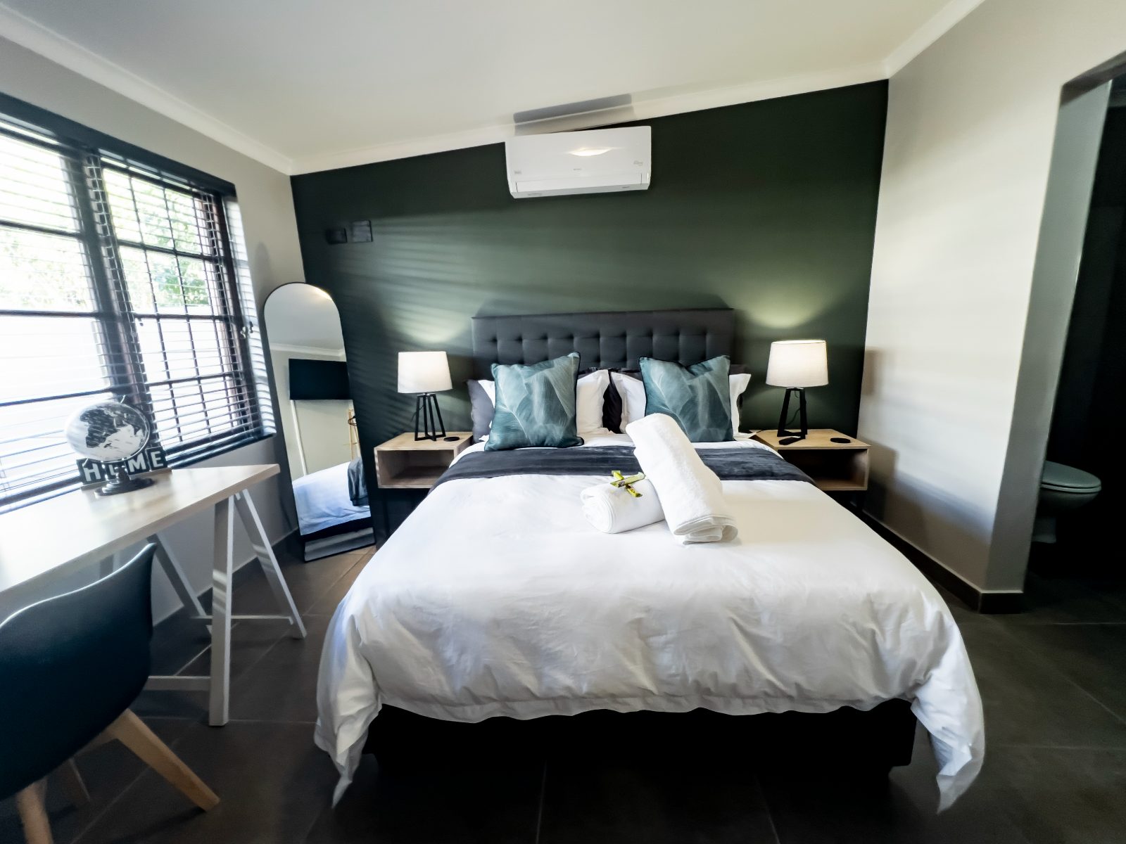 Queen-size bed against the green feature wall